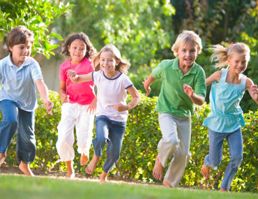Crianças felizes correndo em um campo verde